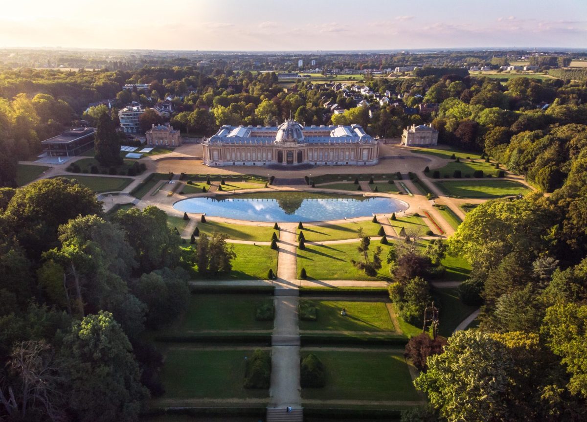 Aerial view of Tervuren's stately home and formal gardens, bathed in golden light.