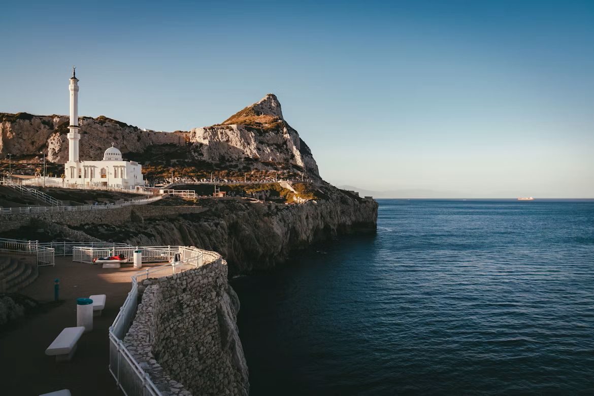 Lighthouse and mosque on rocky Gibraltar coastline overlooking Mediterranean Sea