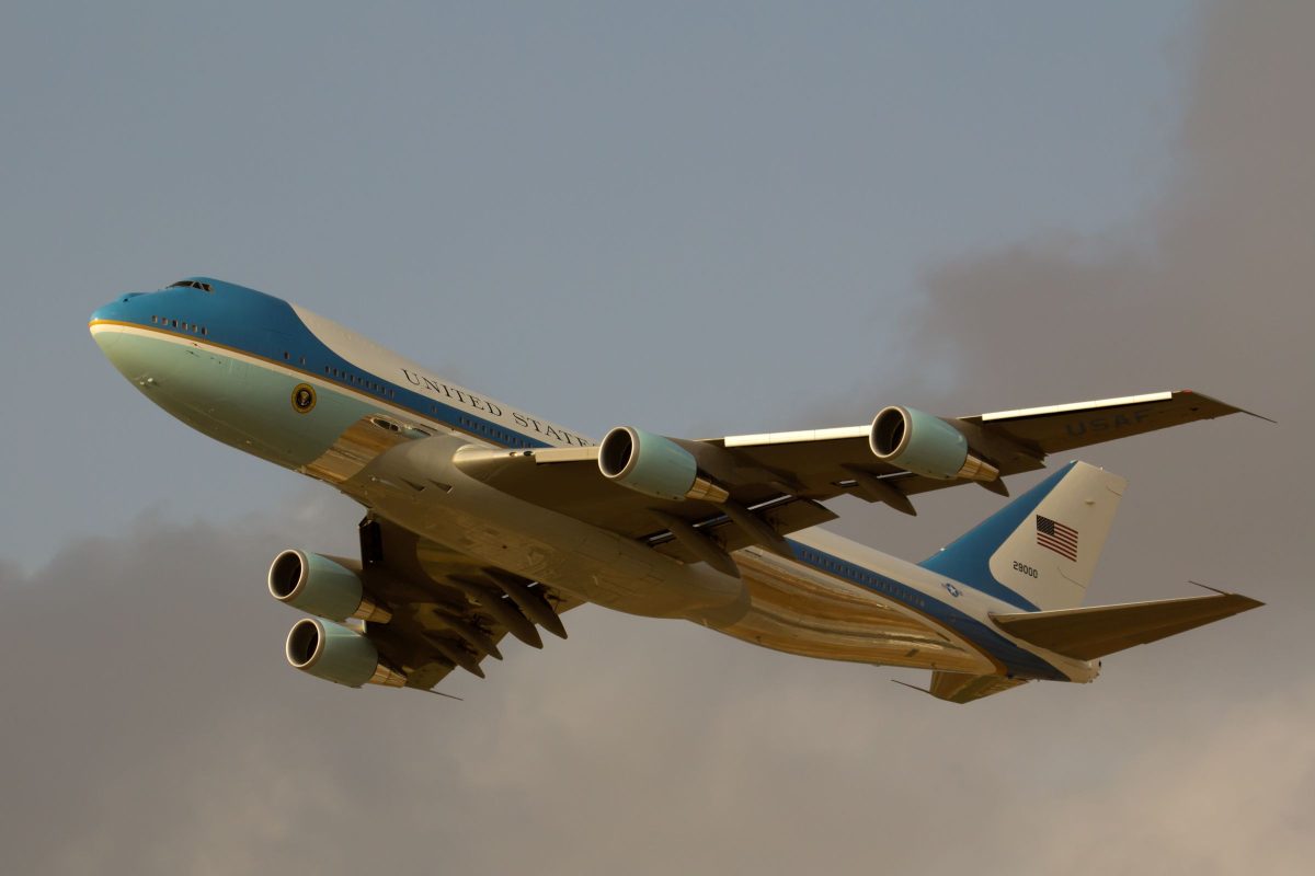 Air Force One Boeing 747 in flight with current blue and white livery against cloudy sky