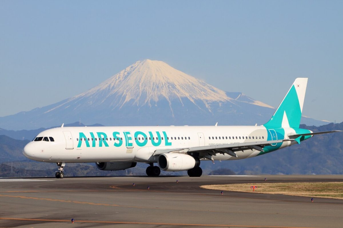Air Seoul aircraft on runway with snow-capped Mount Fuji in background
