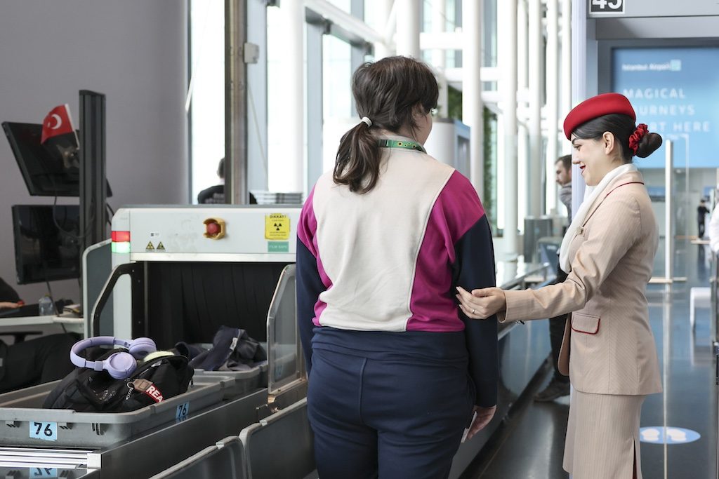 Airport staff member assisting a passenger at a check-in counter