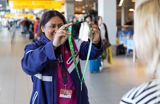 Airport staff member holding medals at Schiphol Airport terminal