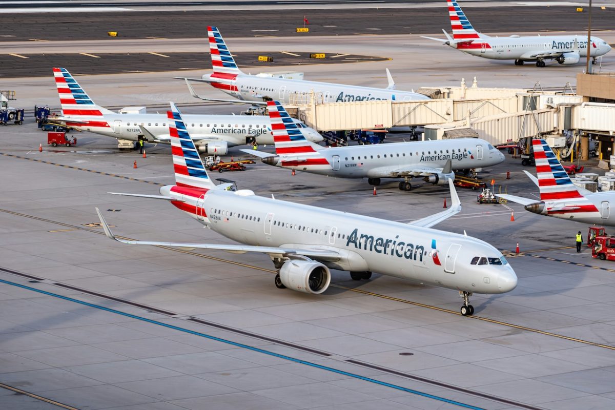 American Airlines aircraft parked at a busy airport terminal during daytime operations.