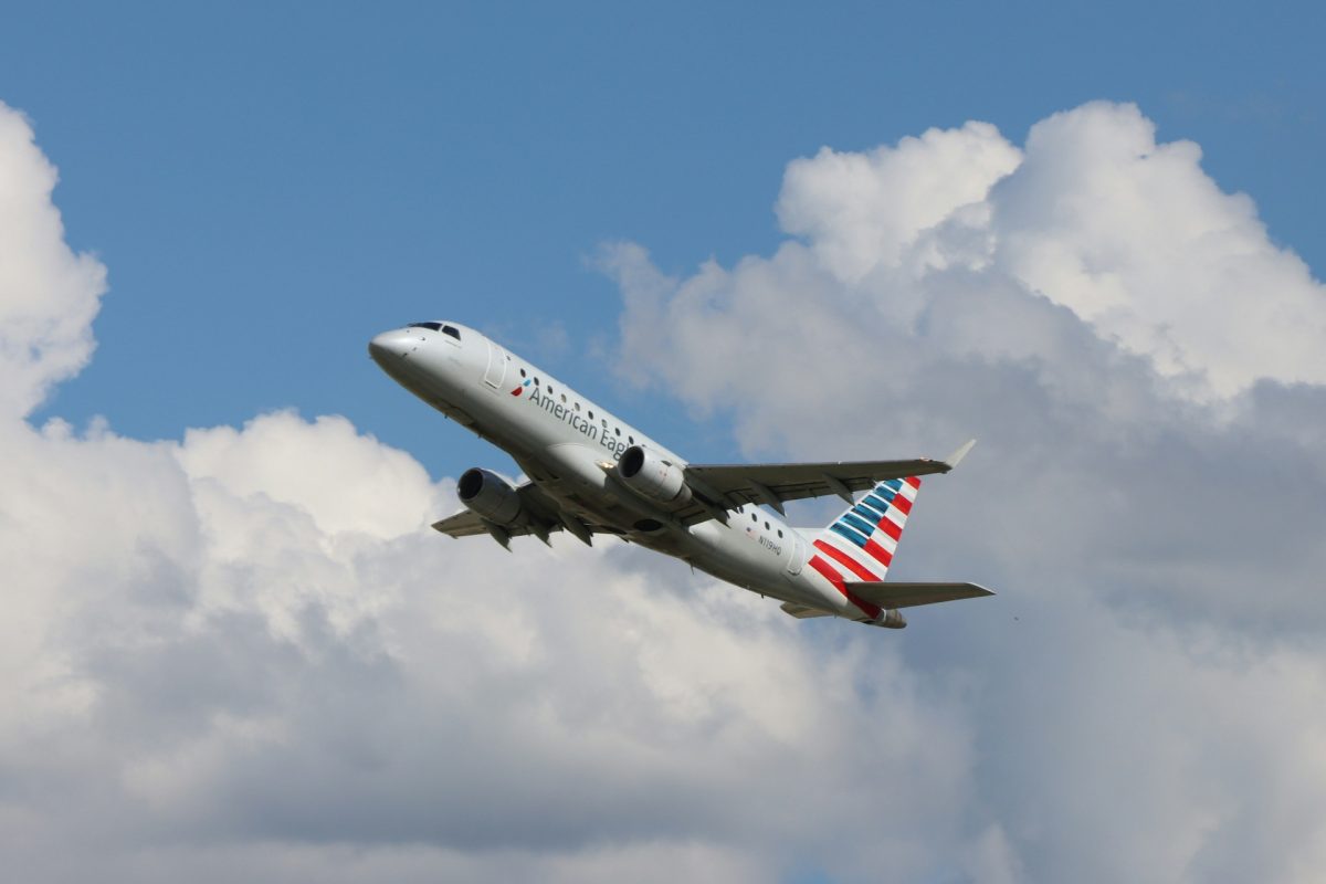 American Airlines aircraft taking off into blue sky with white clouds