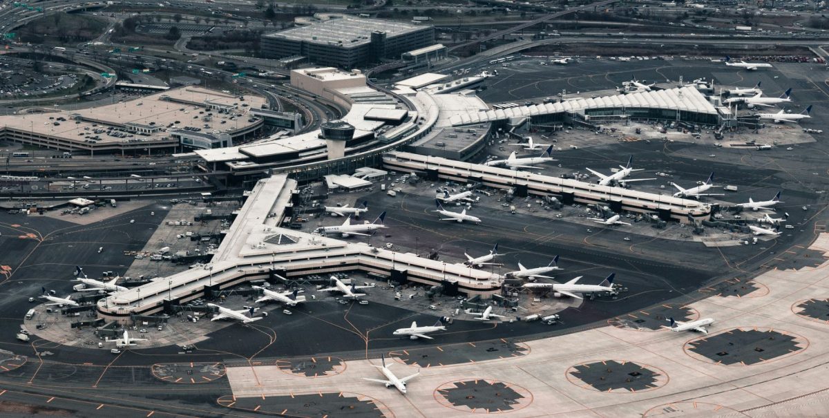 Aerial view of a major airport terminal with multiple aircraft gates and runways