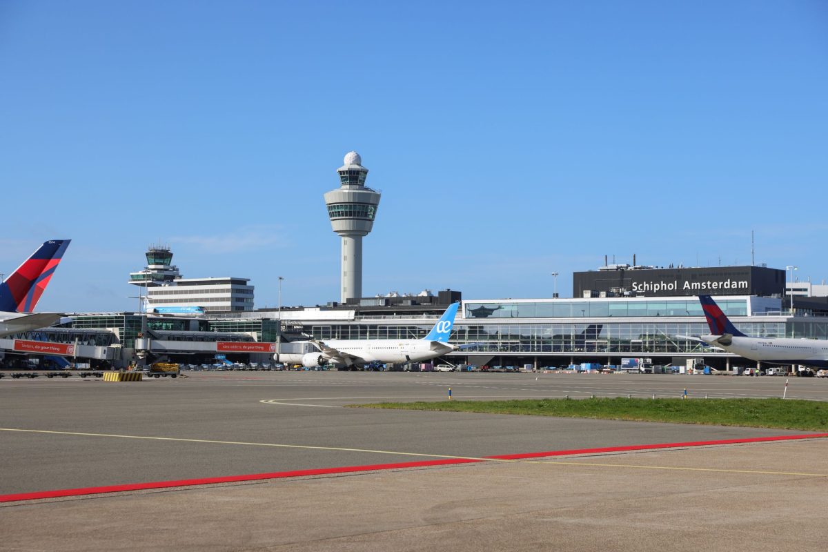 Amsterdam Airport Schiphol terminal with control tower and aircraft parked at gates