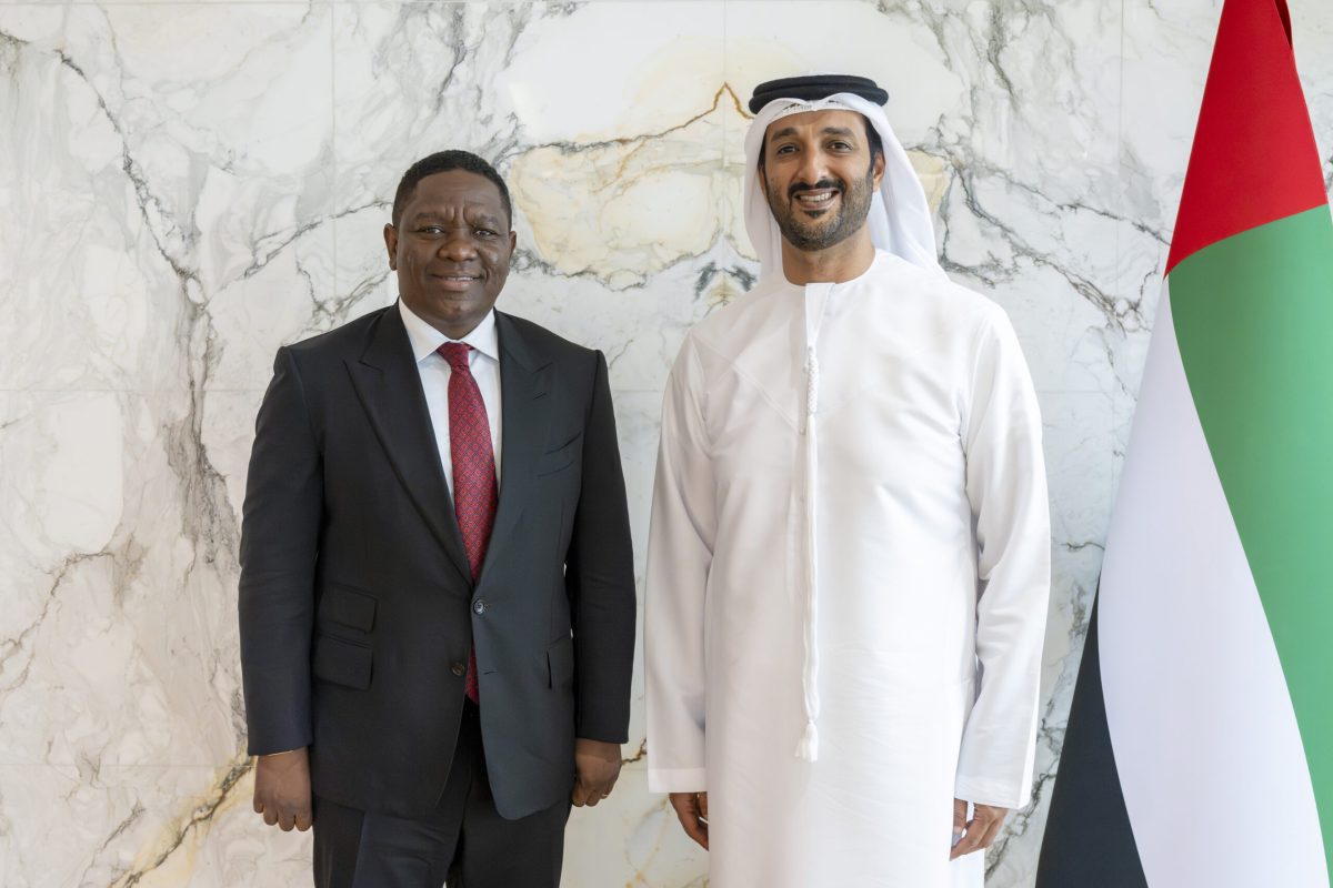 Two officials pose before UAE flag during Angola-UAE tourism partnership meeting