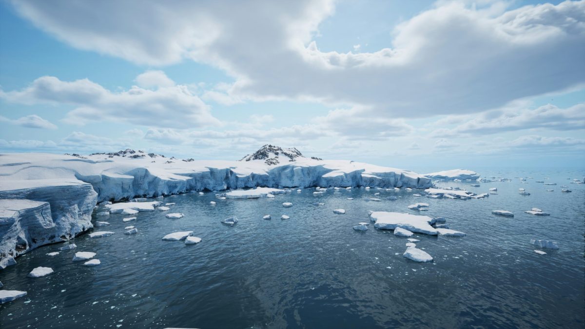 Fragmented ice floes drift in a vast, icy Antarctic seascape under a cloudy sky.