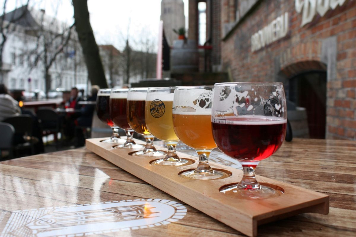 Beer flight tasting paddle with four different Belgian beers on wooden table