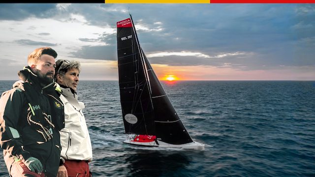 Two Belgian sailors on deck with their racing yacht and sunset ocean backdrop