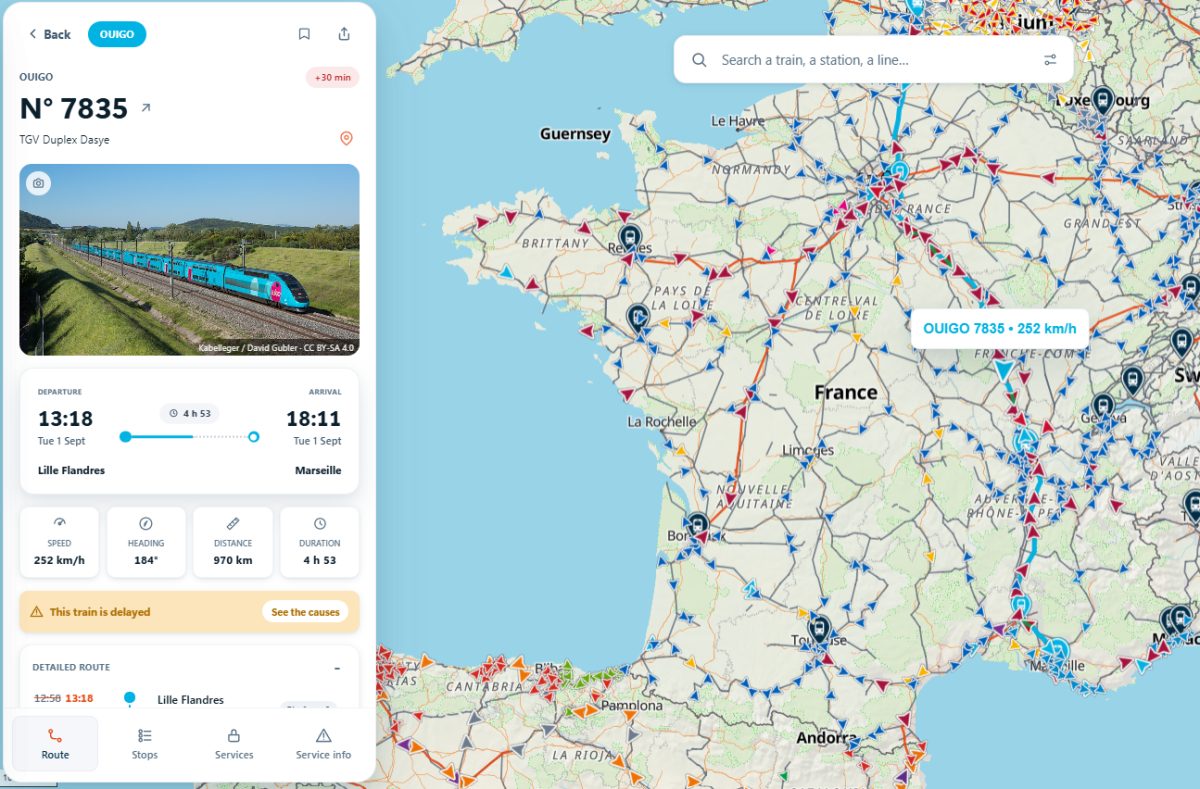 Blue train traveling through rural French countryside on railway tracks