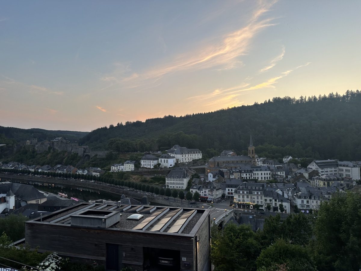 Bouillon town nestled in Ardennes valley at dusk with church spire and forested hills