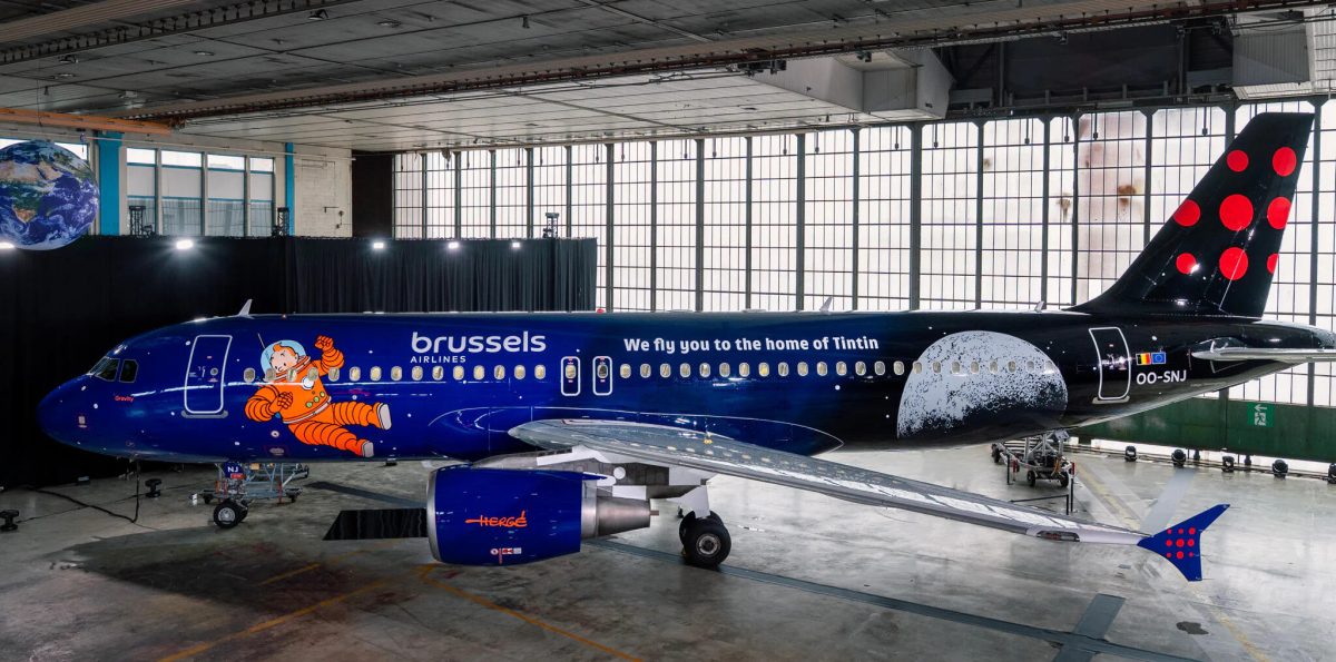 Brussels Airlines aircraft with blue fuselage and orange cartoon character livery in hangar