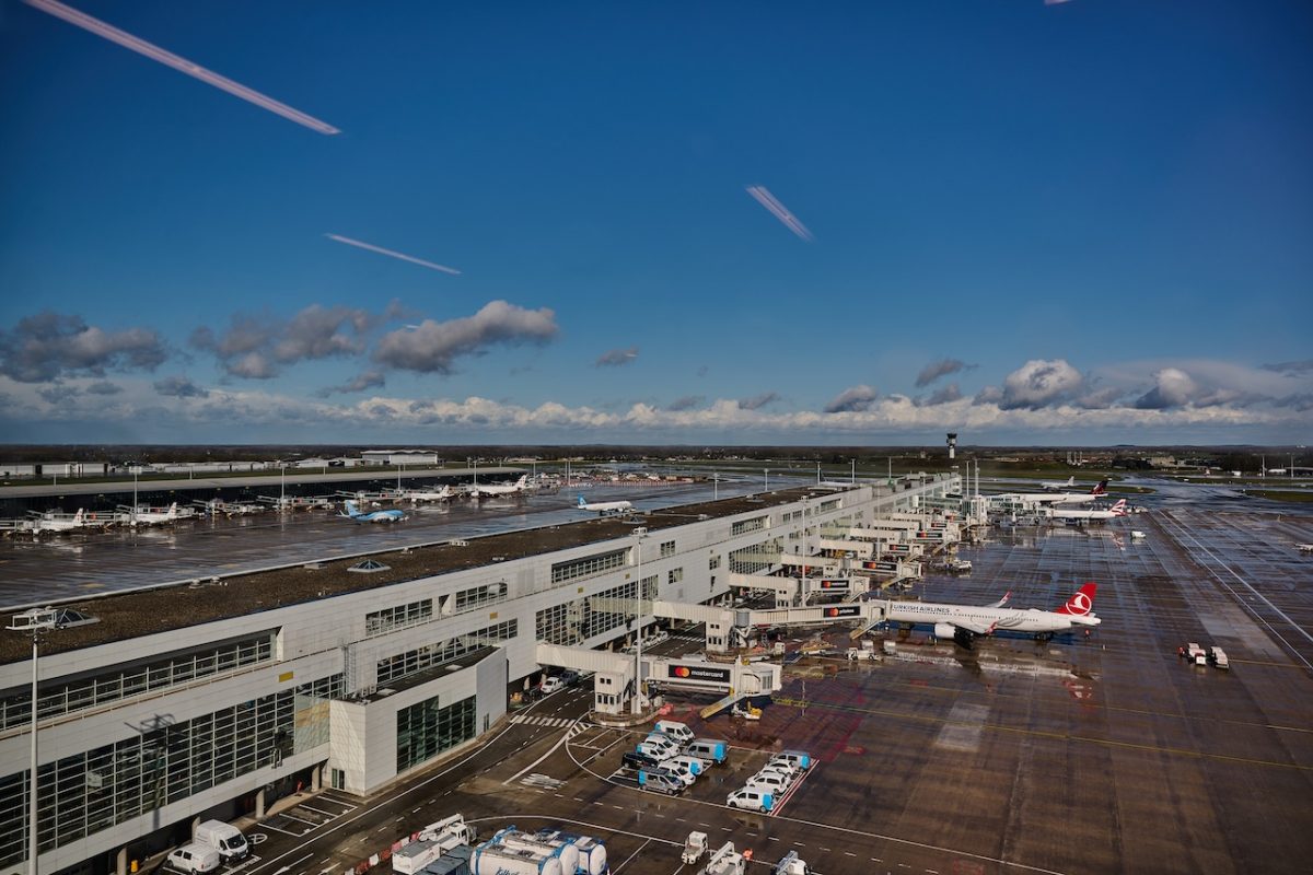 Aerial view of Brussels Airport with multiple aircraft parked at terminals and runways