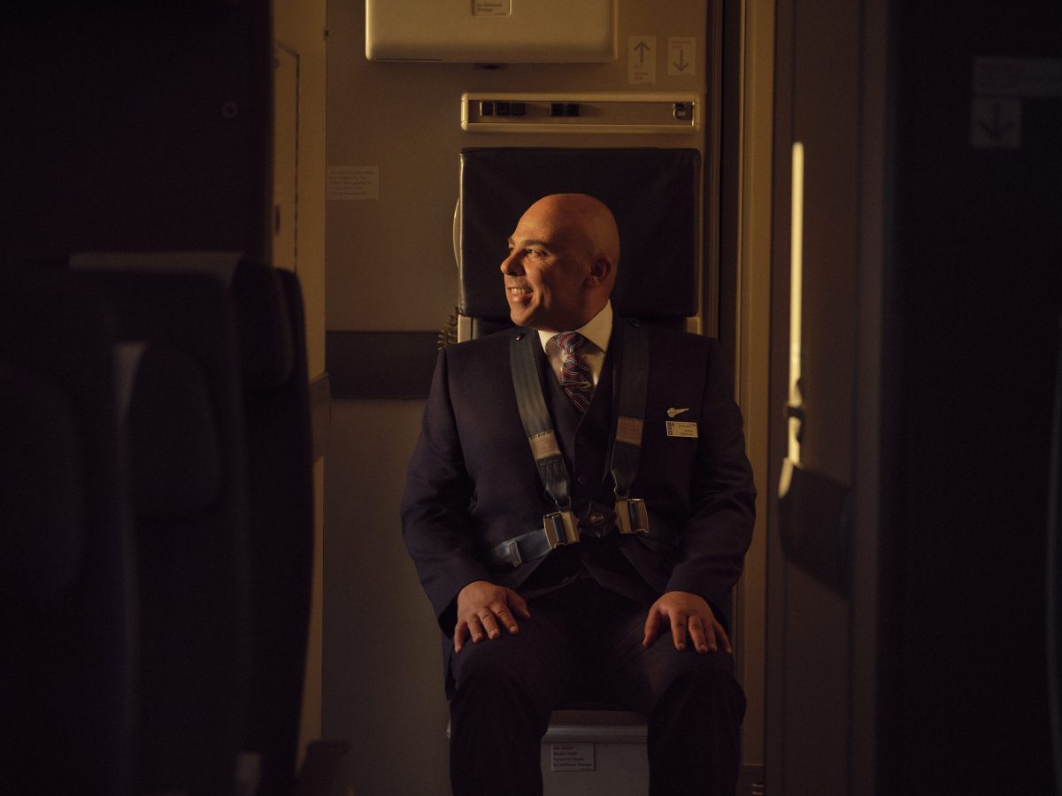 Cabin crew member resting in first-class seat during long-haul flight