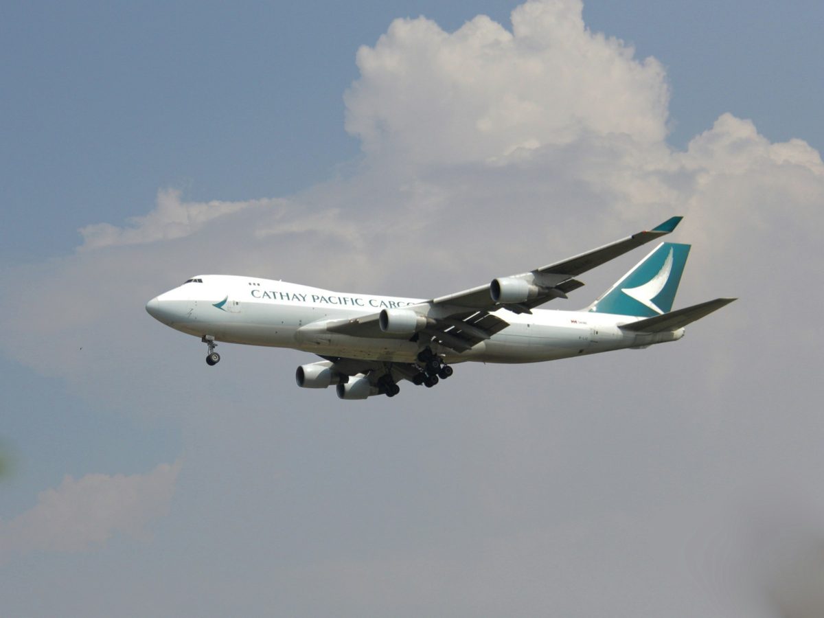 Cathay Pacific Boeing 747 aircraft in flight against cloudy sky