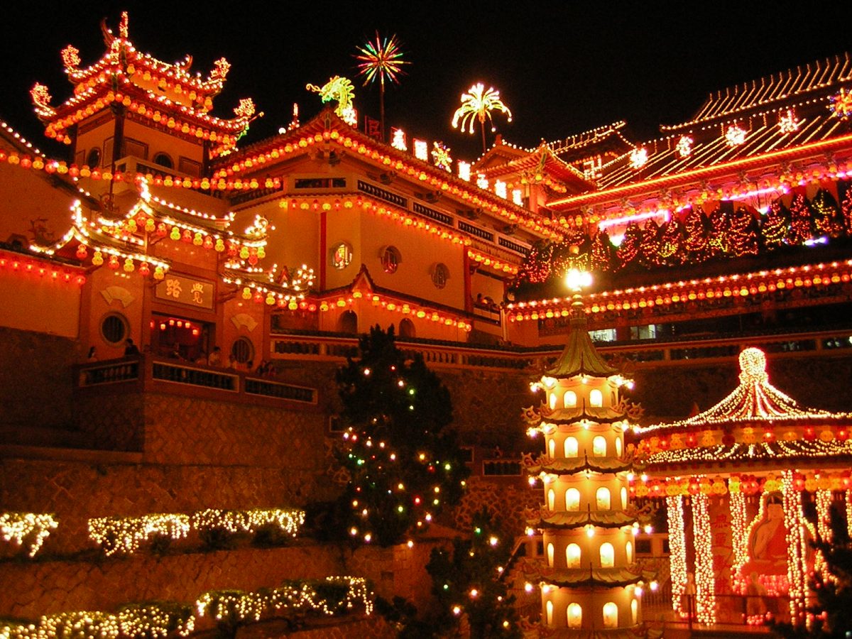 Ornate red temple decorated with thousands of golden lights during Lunar New Year celebrations