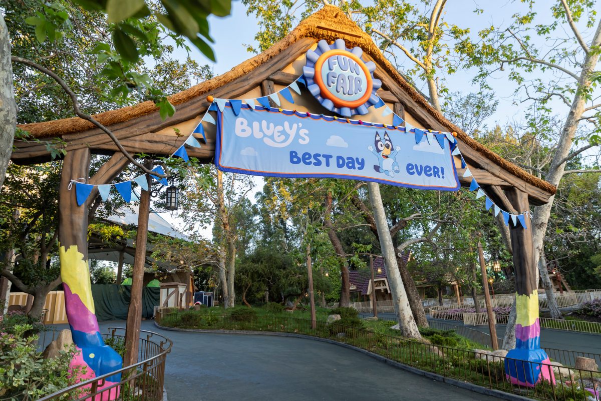 Colorful Bluey-themed entrance archway at Disneyland Resort with blue signage and rainbow decorations
