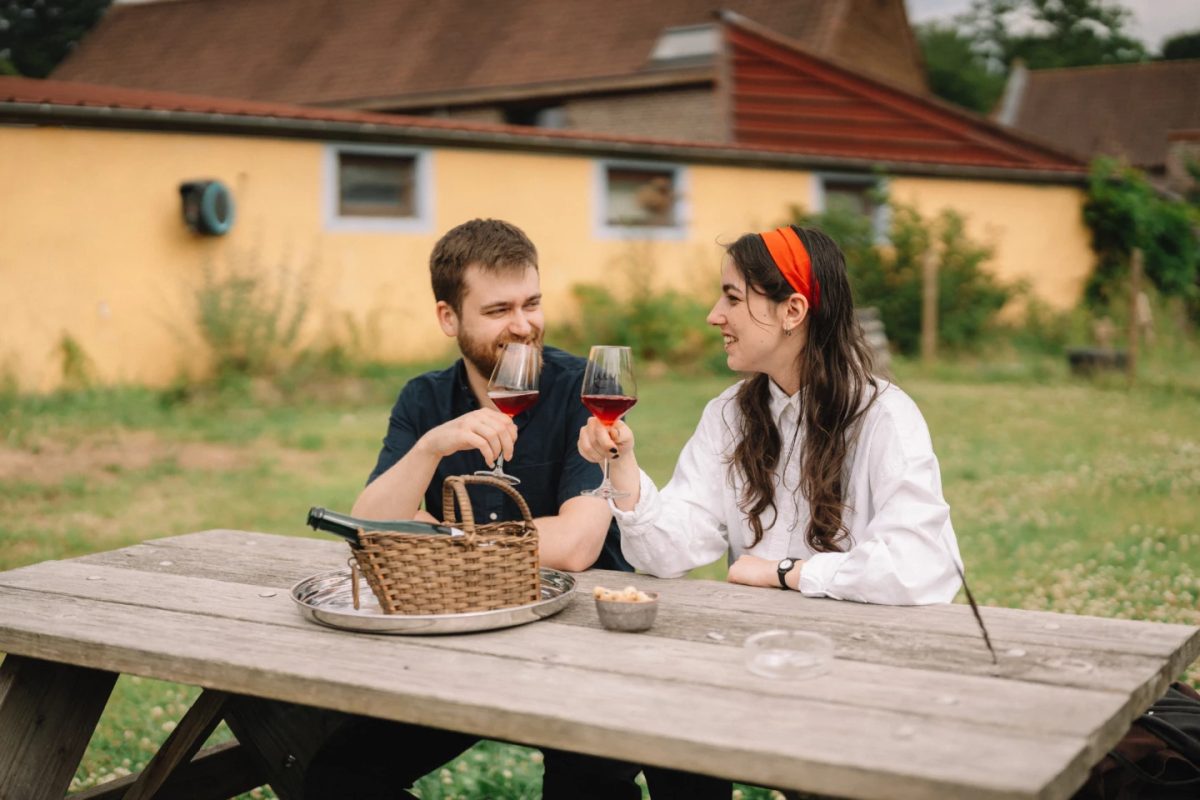 Couple enjoying lambic beer at a brewery in the Belgian countryside.