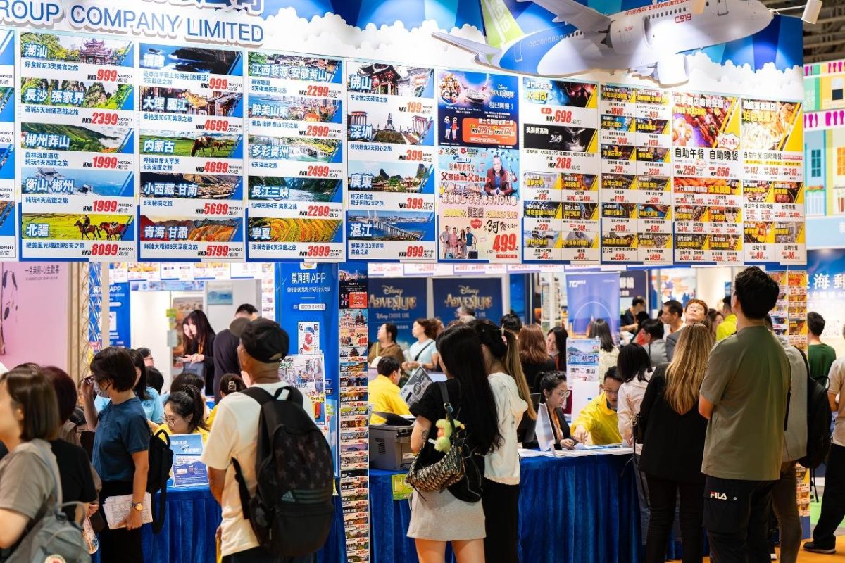 Crowded expo booth with colorful promotional displays and numerous visitors at Macao travel event