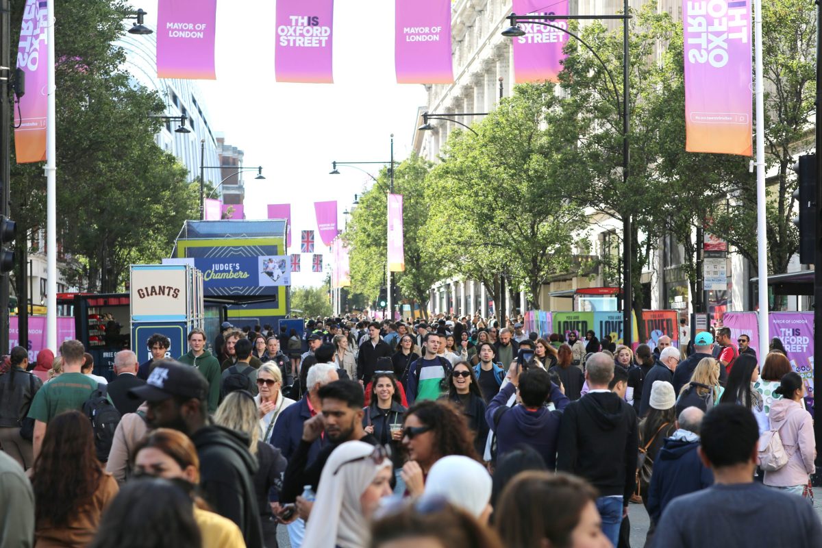 Crowded Oxford Street, London, decorated with banners announcing the pedestrianisation.