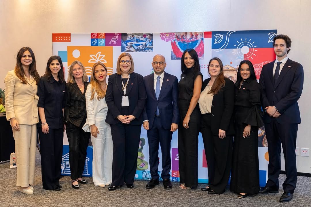 Dominican Republic delegation posing at Brussels trade event with colorful backdrop