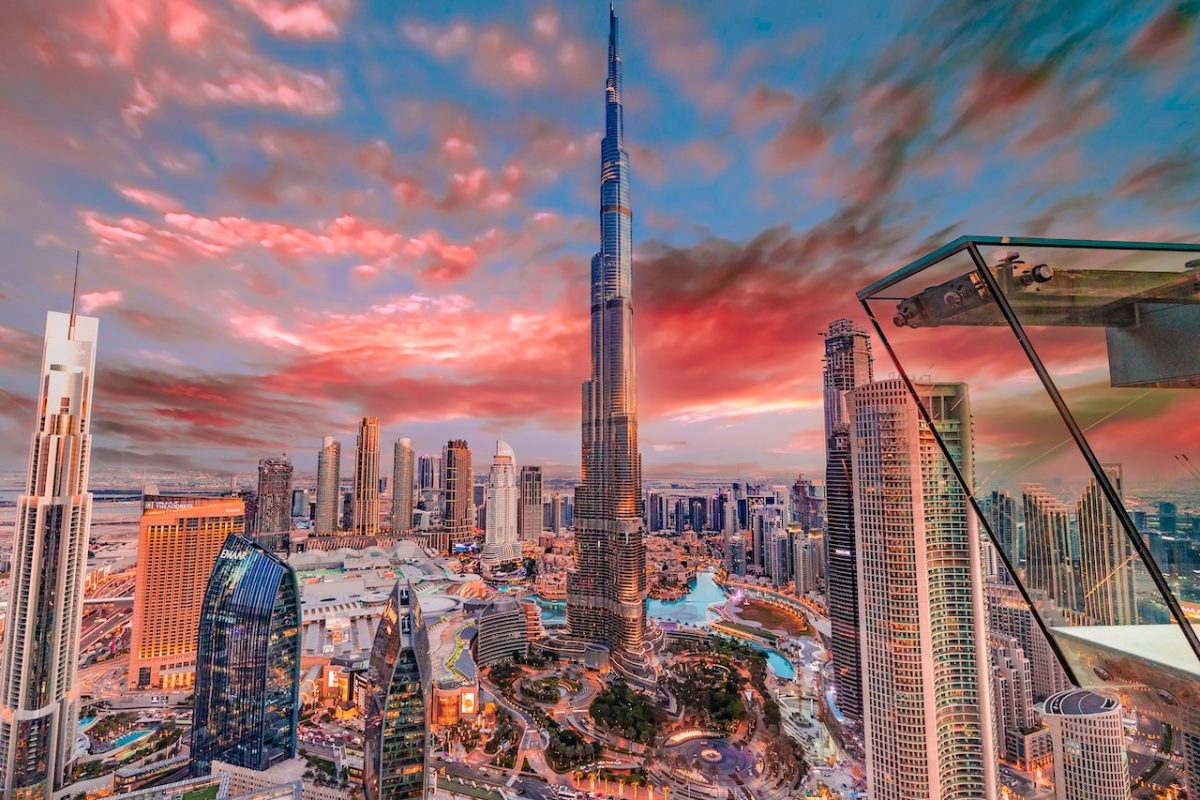 Dubai skyline at sunset with Burj Khalifa and modern skyscrapers under colorful clouds