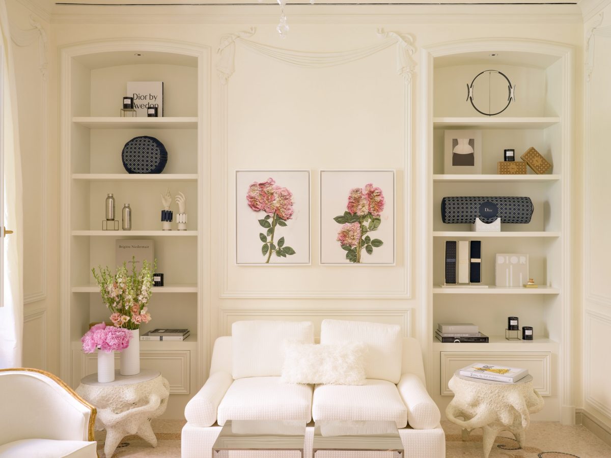 Elegant cream and white interior with built-in shelving, floral artwork, and luxurious seating