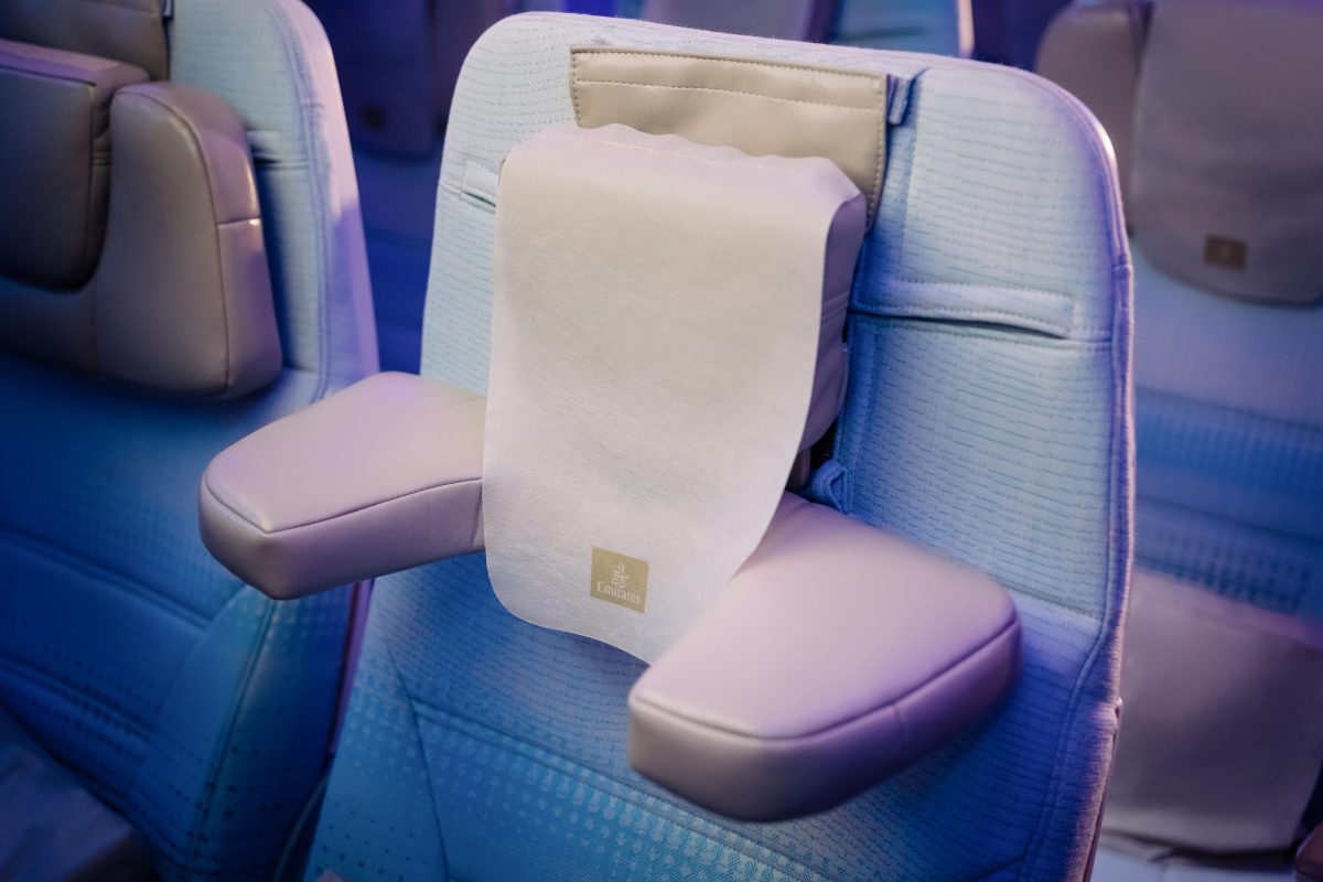 Emirates economy class seat with new white multi-way adjustable headrest