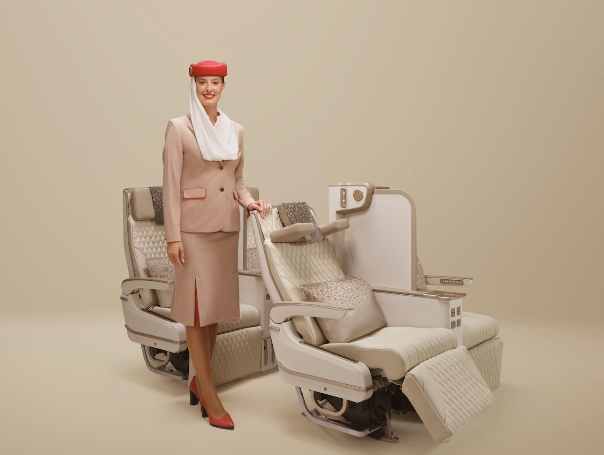 Emirates Premium Economy seat with privacy wall, shown with an attendant.