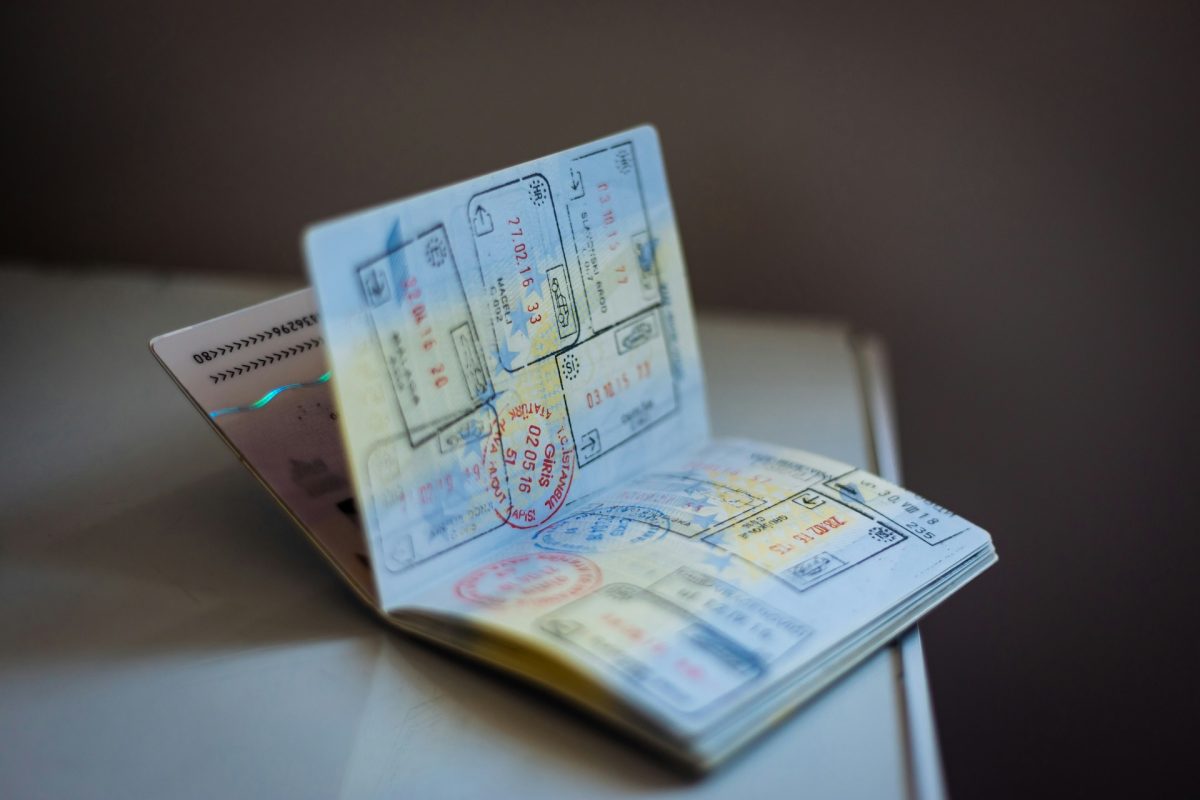 Open passport with visa stamps and travel documents on a white surface