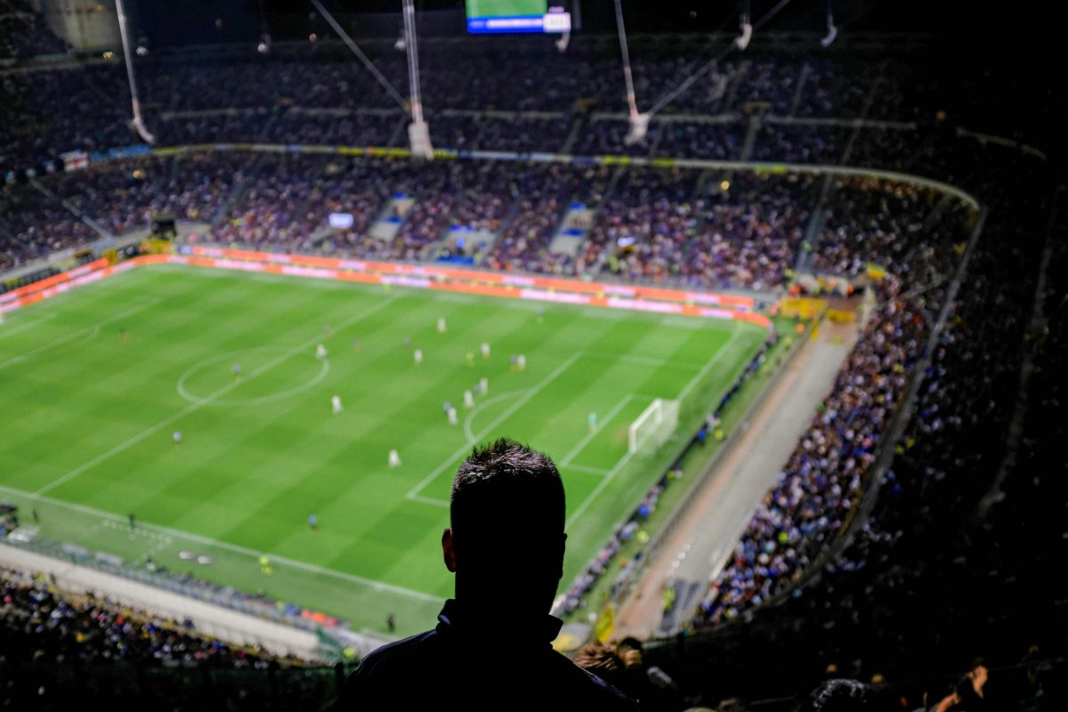 Aerial view of a packed football stadium during a match with crowds in the stands