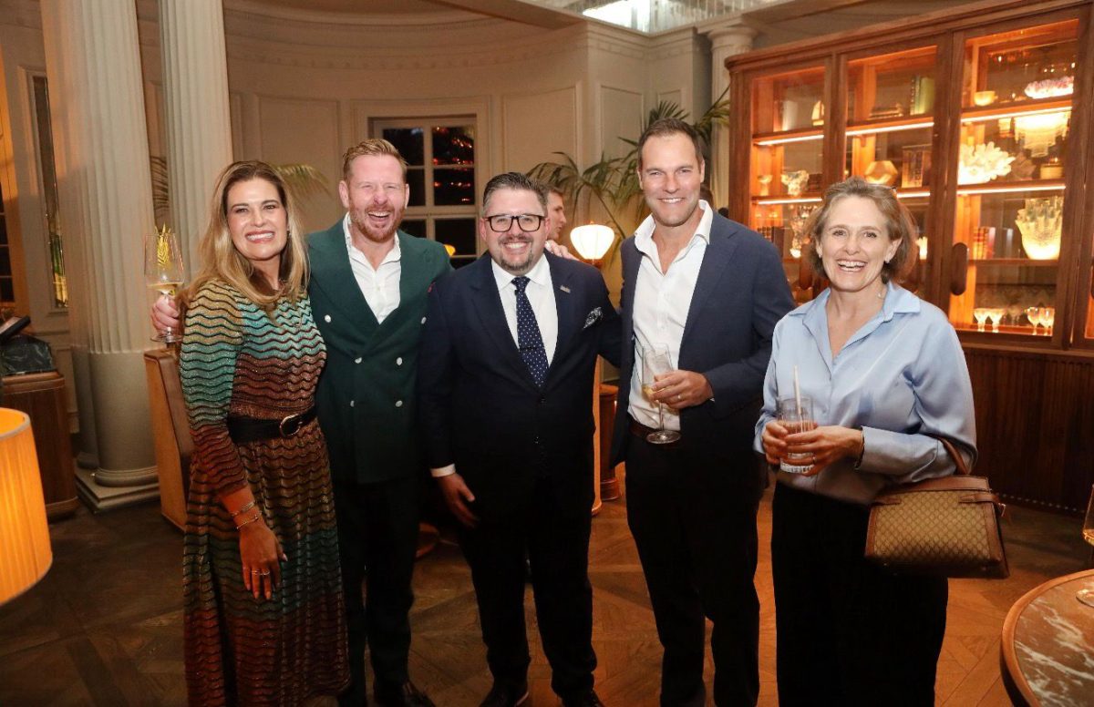 Five tourism industry leaders pose together at an elegant indoor event venue in Cape Town