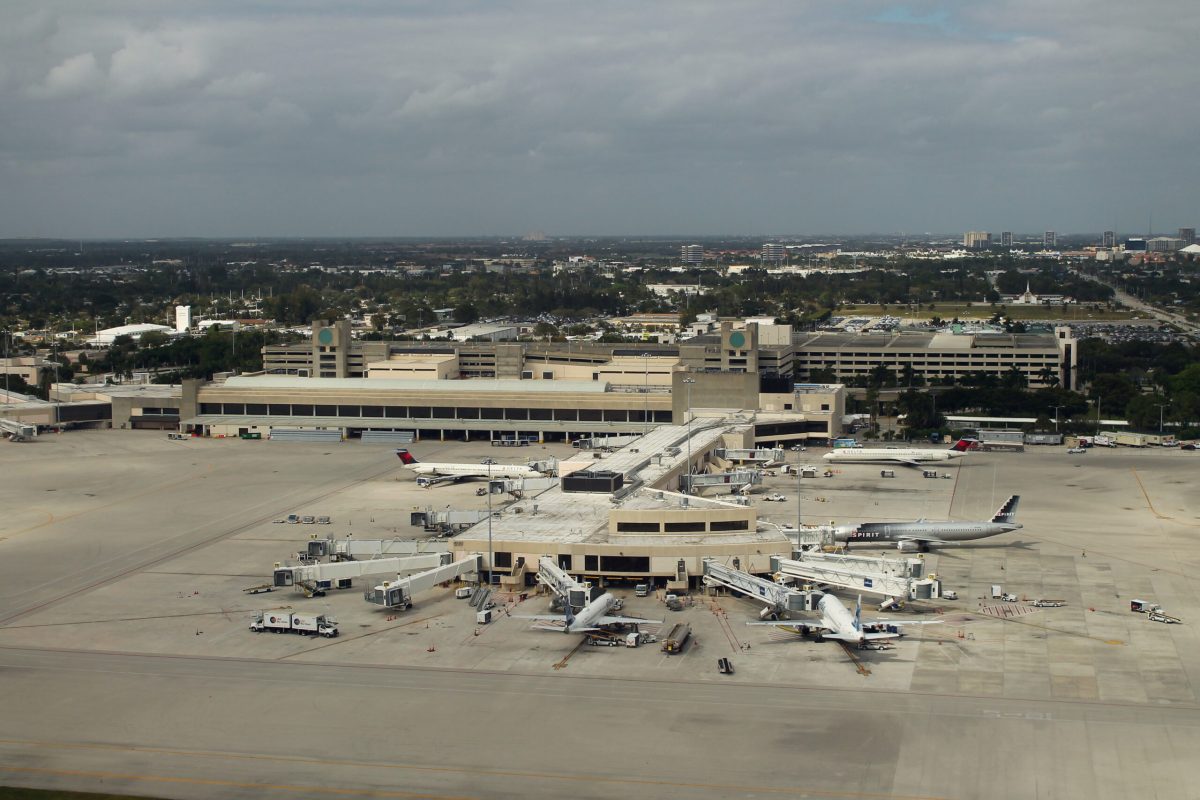 Aerial view of Palm Beach International Airport with planes, ground vehicles, and terminal buildings