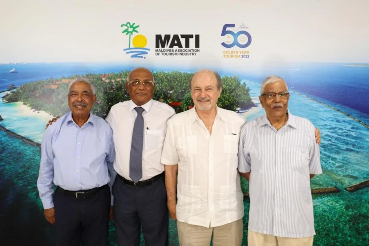 Four men standing in front of MATI logo and tropical island backdrop