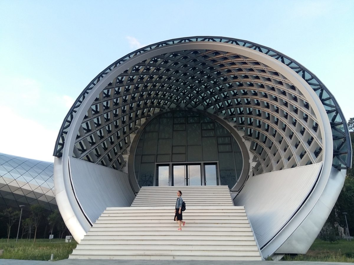 Futuristic white egg-shaped Rike Concert Hall with curved ribbed dome and white staircase entrance