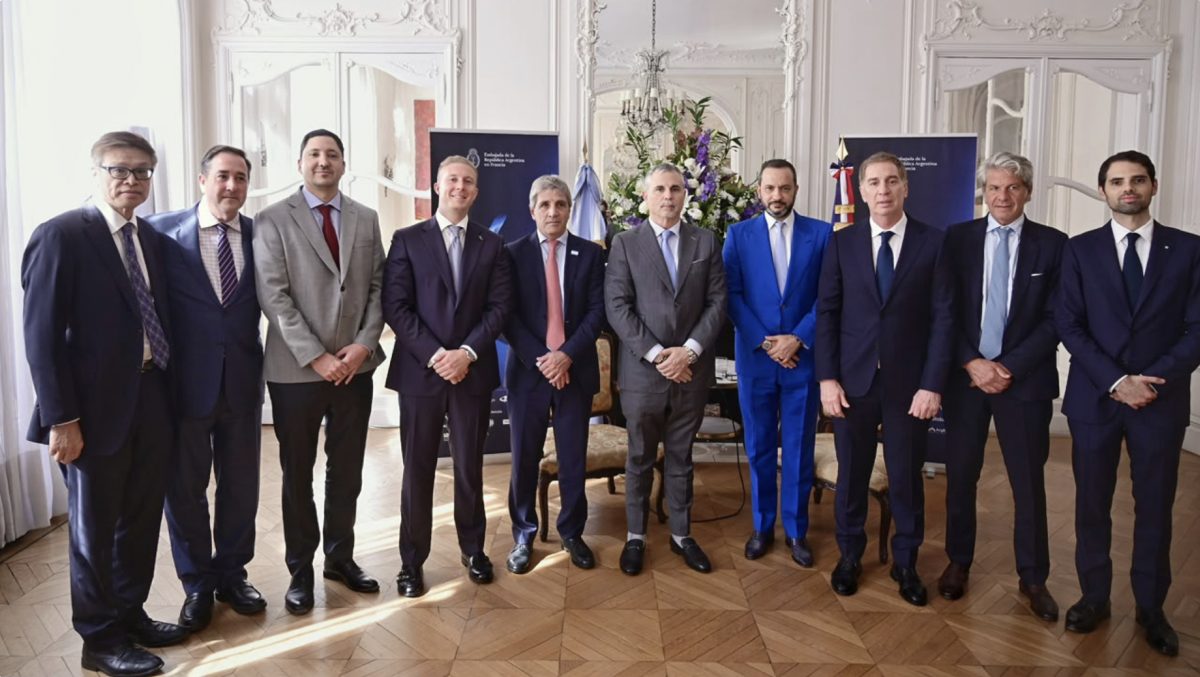 Group of formally dressed men standing in a grand hall.