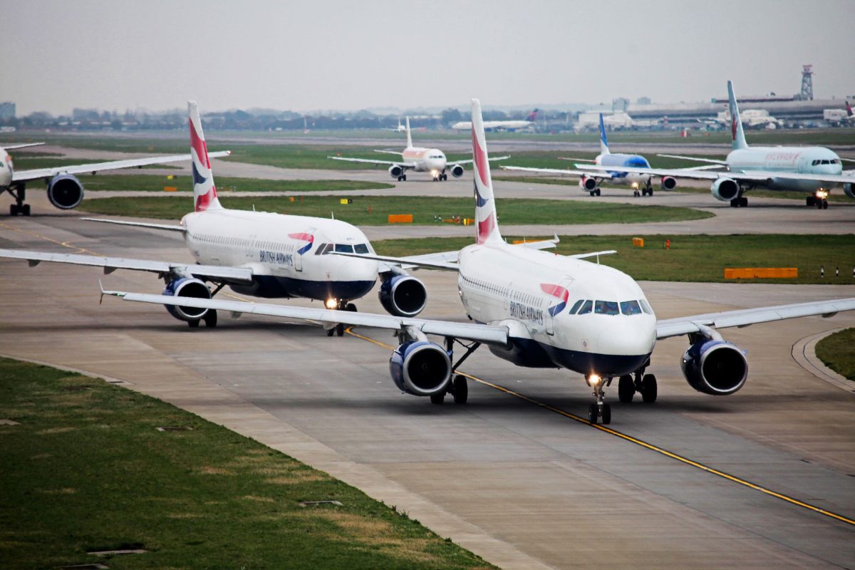 British Airways planes taxiing on Heathrow Airport runway.