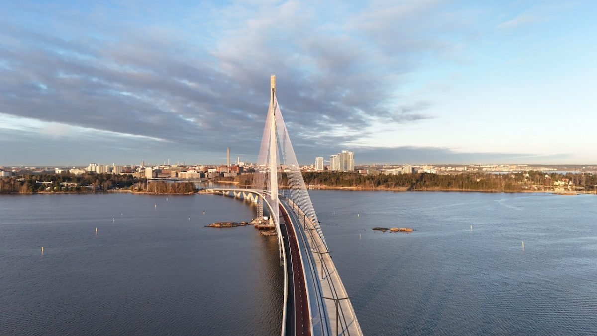 Aerial view of a modern cable-stayed bridge spanning a frozen Finnish waterway