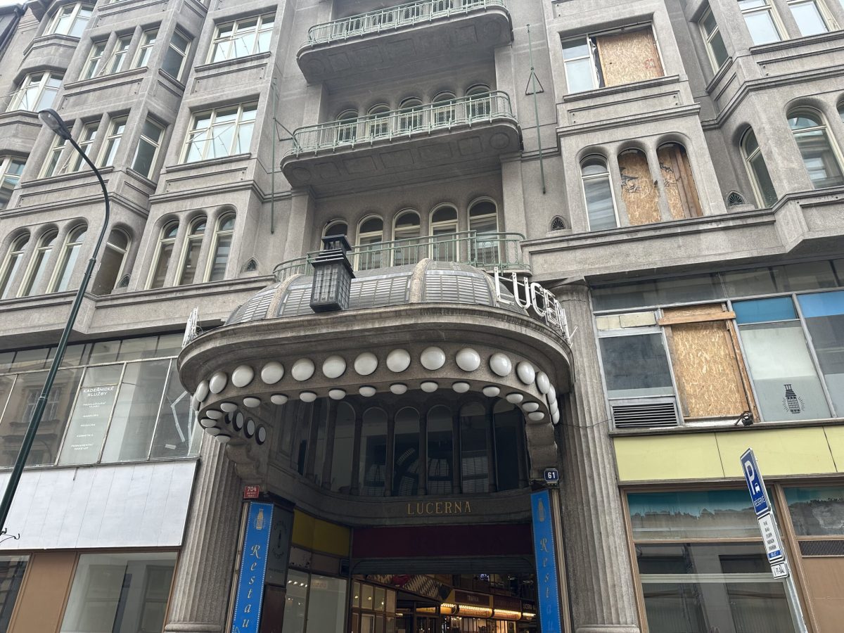 Historic ornate building facade in Prague with decorative circular details and arched entrance