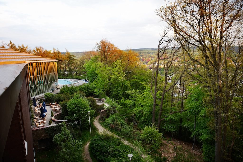 Aerial view of a modern wellness building overlooking forested landscape in Spa, Belgium