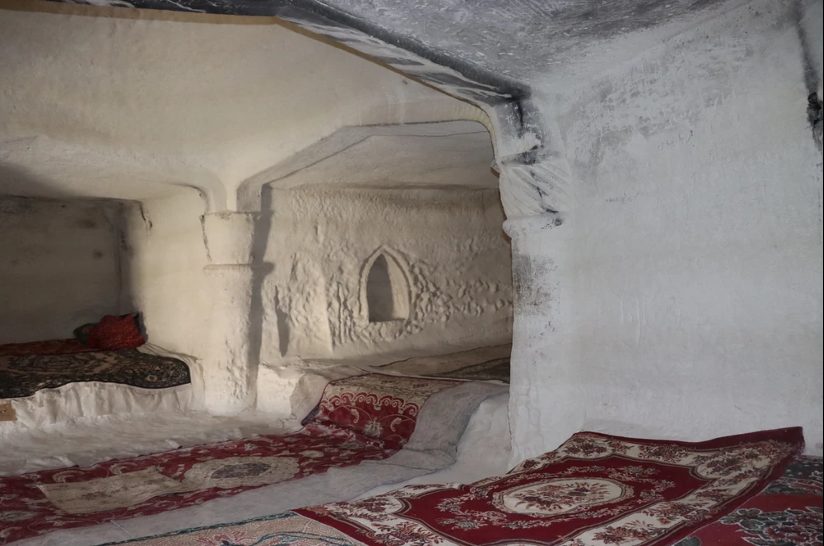 Interior of a traditional Kazakh yurt with carpets and bedding.