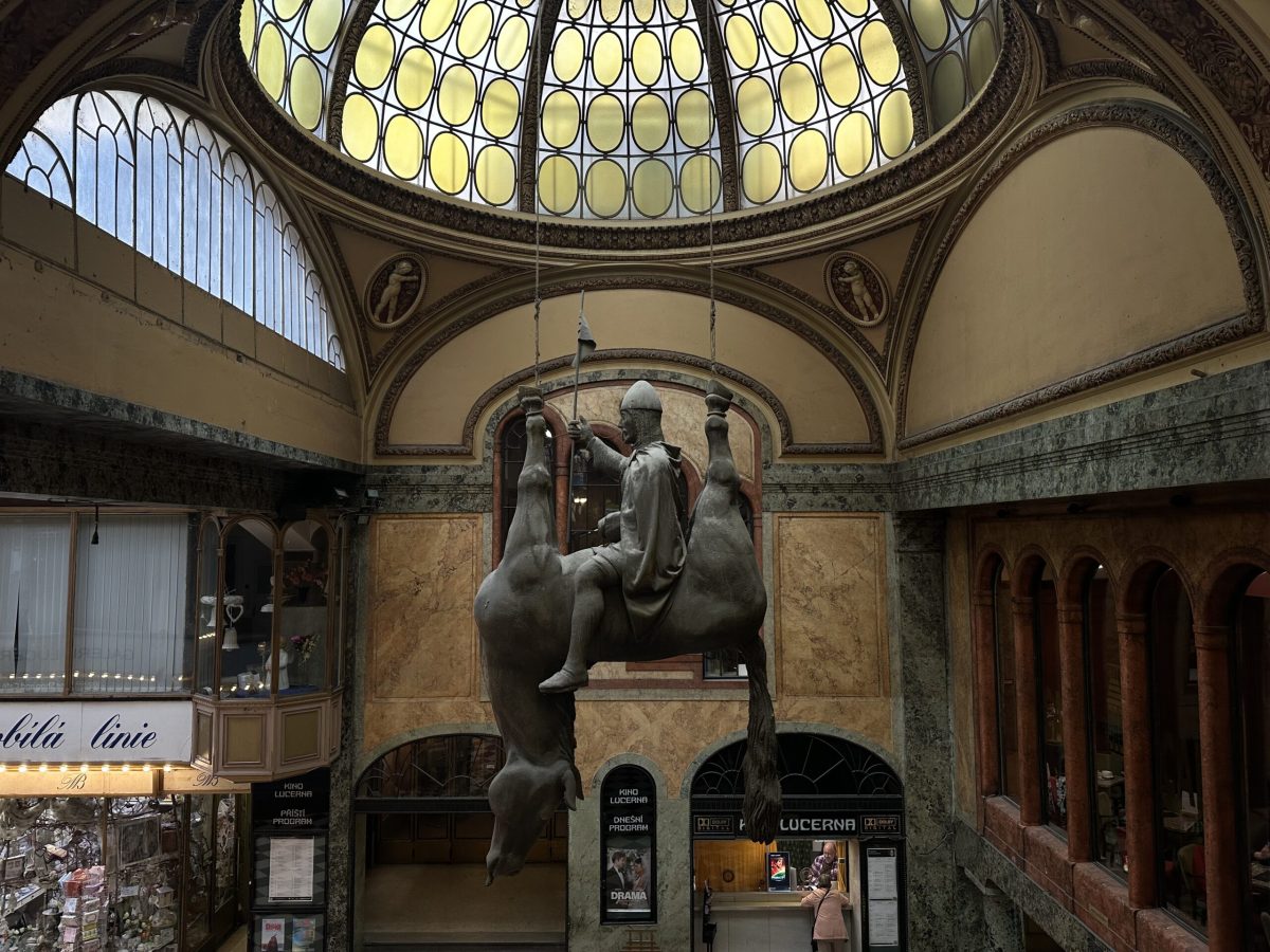 Large bronze sculpture in ornate domed interior space with yellow skylight