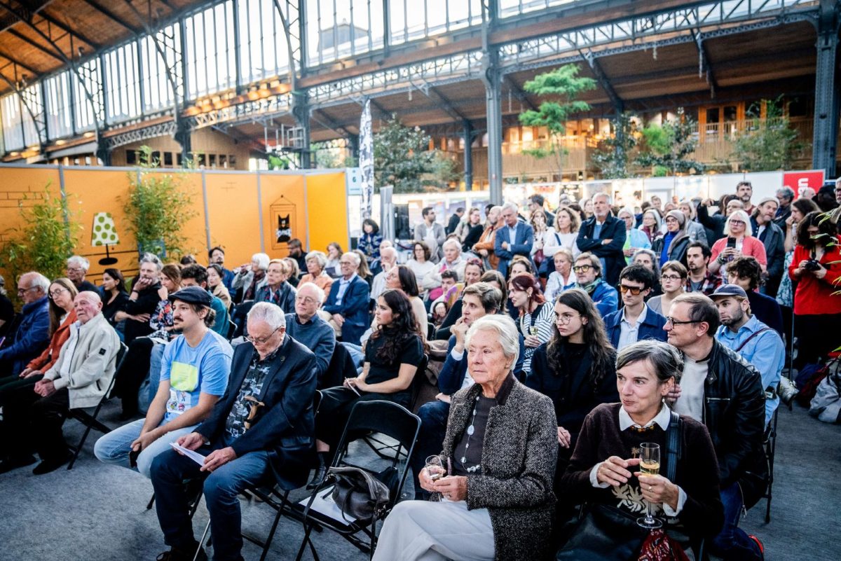 Large crowd gathered indoors at Tour & Taxis venue during Brussels Comic Strip Festival event