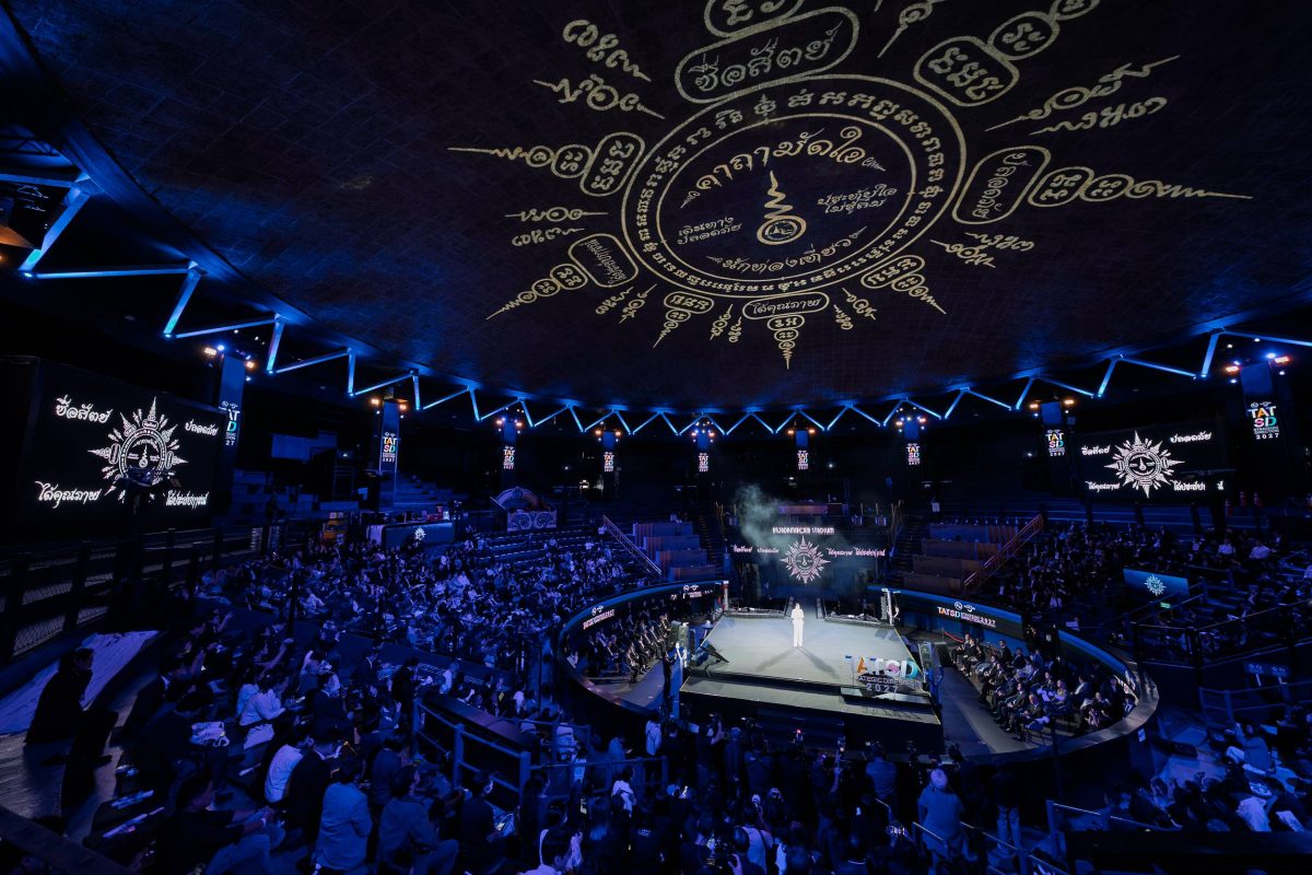 Large indoor arena with blue lighting and zodiac symbols projected on ceiling