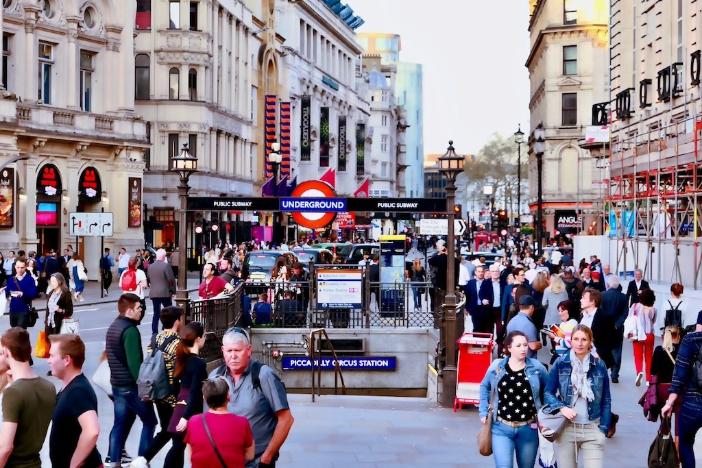 Crowded Piccadilly Circus with iconic red bus and historic buildings