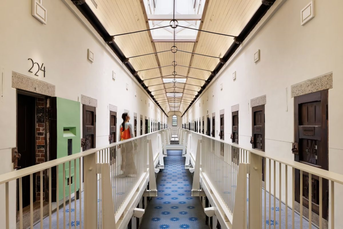 Long symmetrical corridor in a converted prison with cells on both sides and skylights overhead
