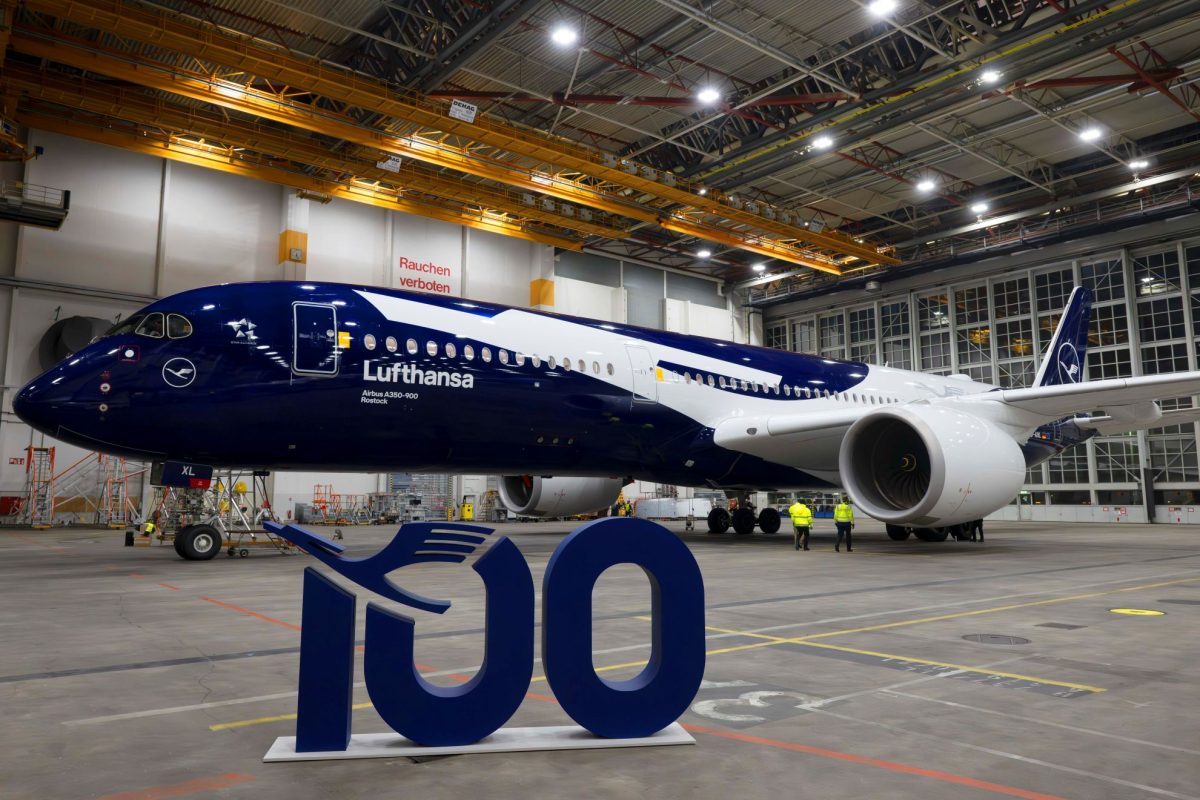 Lufthansa Boeing 787 Dreamliner with large blue 100 numeral in hangar