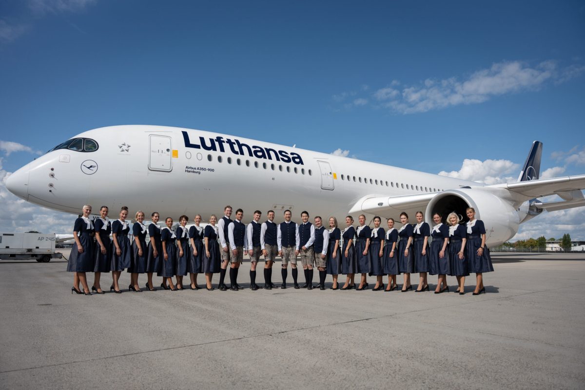 Lufthansa crew in traditional Bavarian outfits pose in front of an Airbus A350.