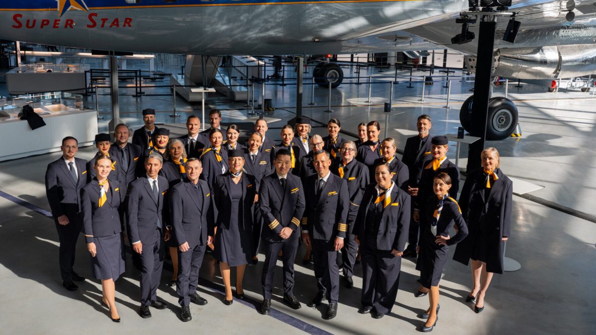 Lufthansa staff wearing new Hugo Boss uniforms posed in front of aircraft